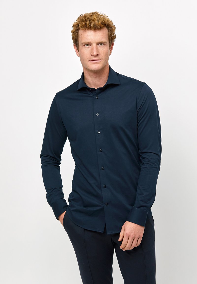 Camicia a maniche lunghe blu navy con chiusura a bottoni, dotata di colletto a punta e bottoni neri, realizzata in un tessuto liscio e leggero.