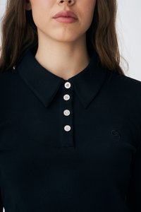 Čierna rebrovaná polokošeľa s knoflíkovou légou, ktorá obsahuje štyri gombíky pripomínajúce krištáľ a má špicatý golier. Na ľavej strane je jemný detail loga.
