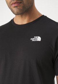 The North Face M SS BOX NSE TEE - T-shirts med print - black/optic emerald