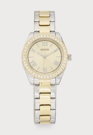 Reloj de pulsera de metal dorado y plateado con esfera redonda, números romanos, acentos de cristal alrededor del bisel y una pulsera de eslabones en dos tonos.