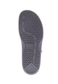 Zwarte rubberen zool met een zigzagprofiel, een getextureerd oppervlak met schokabsorberende details en verhoogde branding aan de zijkant.