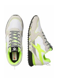 Scarpe sportive caratterizzate da una combinazione di mesh e suede grigio e bianco, accentuate da dettagli giallo neon e una suola nera testurizzata.