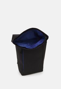 Črna torba z zadrgo, z modrim notranjim podloženjem in sodobnim, elegantnim dizajnom. Narejena iz trpežnega materiala z minimalnimi dodatki.