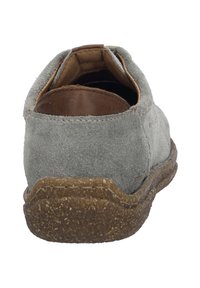 Šedá semišová bota s hnědým koženým akcentem na patě, s texturovanou gumovou podrážkou a zaobleným tvarem. Zadní pohled ukazuje vnitřní podšívku.