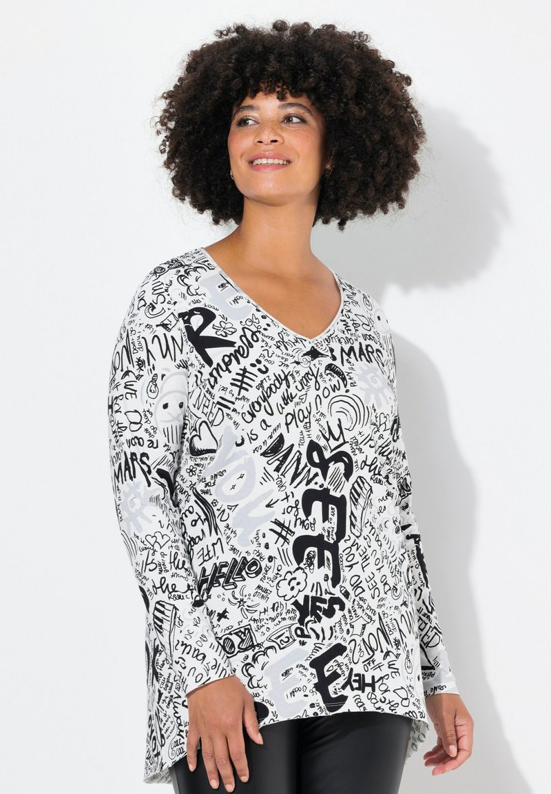 Maglietta a maniche lunghe con scollo a V in bianco, decorata con testi grafici neri e scarabocchi. Tessuto leggero con una vestibilità rilassata e spacchi laterali per facilitare i movimenti.