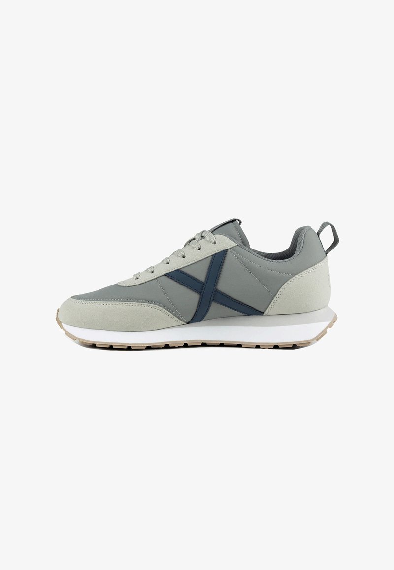 Baskets grises et beige clair avec une bande transversale bleue, semelle blanche, lacets à l'avant et languette au talon, vues de côté droit.