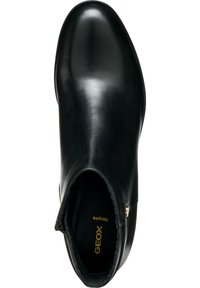 Bottes de cheville en cuir noir avec une finition lisse, bout pointu et panneau élastique latéral. Caractéristiques d'un accent métallique et d'une semelle intérieure avec logo.