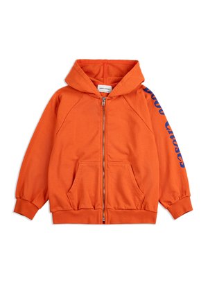 Svetlo oranžová mikina na zips s prednými vreckami, rebrovanými lemami a textom "Bobo Choses" modrou farbou na pravom rukáve.
