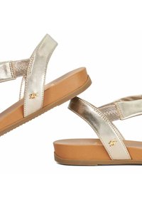 Metallic gouden sandalen met een gestructureerde band en een platte tan rubberen zool. Bevat merklogo-details op de banddecoratie.
