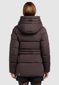 Brun oppustet jakke med en høj, rund krave. Har et quiltet design, justerbar hætte og sidelommer. Glat, reflekterende stof.