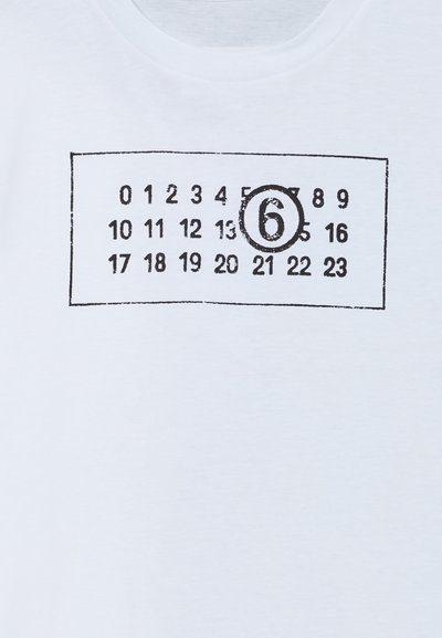 T-shirt bianco in cotone con un design di calendario stampato in nero, con numeri e un "6" cerchiato in evidenza. Collo rotondo, maniche corte.