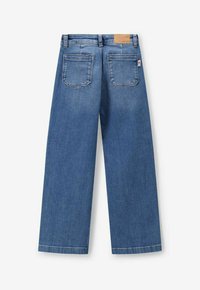 Jean large en denim bleu avec une taille haute, deux poches arrière et une étiquette en cuir sur la ceinture. Texture lisse, design décontracté.