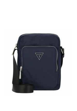 Bolso bandolera compacto azul marino con bolsillo frontal con cremallera, logo plateado de GUESS y correa negra ajustable.