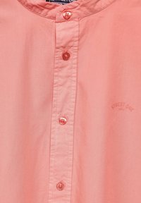 Korálově růžová košile na knoflíky vyrobená z lehké tkaniny, s stojáčkovým límcem, šesti knoflíky a vyraženým logem.