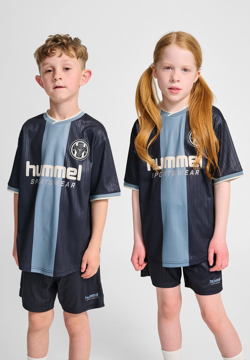 Två barn som bär matchande svarta och ljusblå randiga sporttröjor och shorts, med en logotyp och texten "hummel" i vitt.