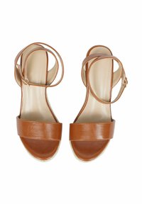 Sandali in pelle marrone con una larga fascia sul piede, una fascia alla caviglia e una suola in espadrilles texture. Il design presenta linee lisce e minimaliste.