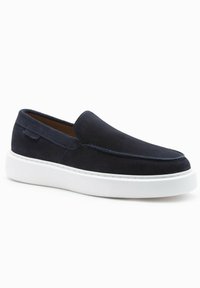 Chaussure pour homme en daim bleu marine à enfiler, semelle épaisse en caoutchouc blanc, style mocassin décontracté, couture minimale et design à bout rond.