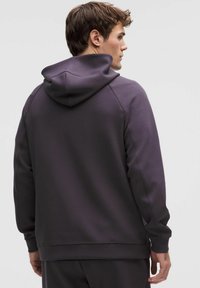 Mørkelilla hættetrøje lavet af glat stof med snøre i hætten, lange ærmer og ribstrikkede manchetter med et enkelt design.