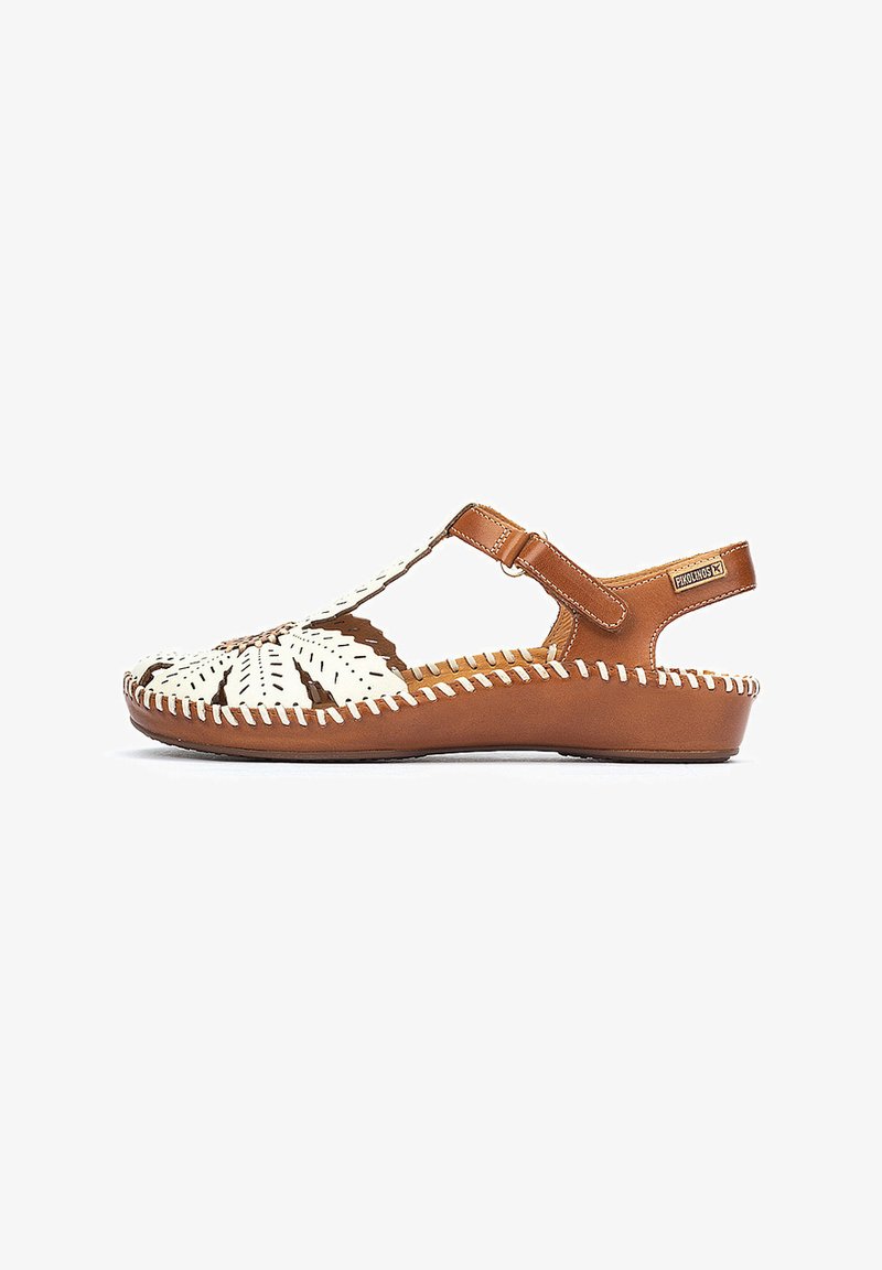 Sandale en cuir marron avec motif tissé blanc, bout fermé, dos ouvert et sangle ajustable. Présente des coutures décoratives le long du bord.