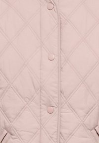 Veste matelassée rose avec un motif en losange, fermetures à boutons-pression et poches latérales. Le tissu présente une texture lisse et une légère isolation.