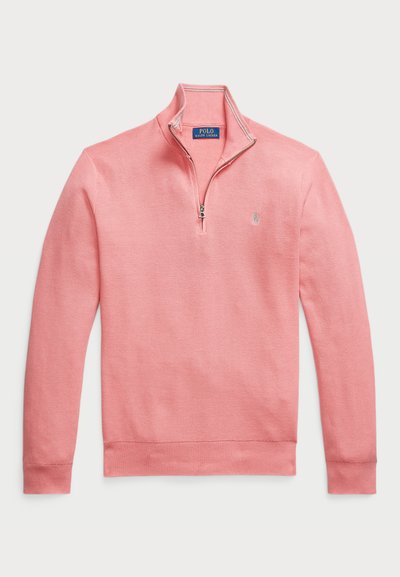 Pull en tricot rose clair avec un col zippé quart. Il présente des poignets et un ourlet côtelés, confectionné dans un tissu en tricot texturé avec un petit logo sur la poitrine.