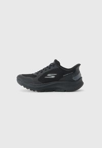 Juodas „Skechers“ sportinis batelis su tinklo viršumi, raištelių dizainu ir paminkštintu padu, pažymėtas "Ultra Light", ant baltos fono.