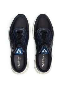 Pari di sneakers in pelle nere e blu navy con suole bianche e lacci neri, nome del marchio "MARTINE" visibile all'interno di ogni scarpa.