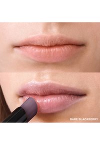 Application de produit à lèvres sur les lèvres. La partie supérieure montre une couleur naturelle des lèvres ; la partie inférieure montre une lèvre brillante et pigmentée avec une pointe arrondie de couleur violet foncé.