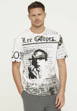Witte graphic t-shirt met zwarte en grijze tekst, krantenpatronen en een artistiek beeld van een persoon die een sigaret vasthoudt.