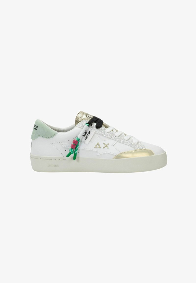 Weißer Sneaker mit niedrigem Schaft, goldenen Akzenten, mintgrünem Fersenbereich, schwarz-weißen Schnürsenkeln, Glitzerstreifen und grünem Etikett mit der Aufschrift "RUN FASTER".