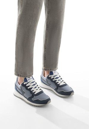Blue and gray sneaker with a mix of fabric and suede. Features white laces, a cushioned sole, and a textured rubber outsole.