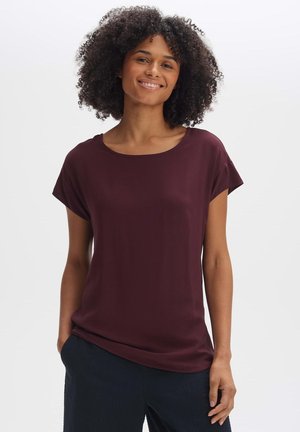 Burgundy short-sleeve top with a rounded neckline, made from soft fabric; features a relaxed fit and smooth texture.