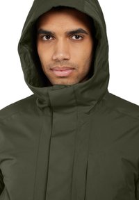 Khaki Regenjacke mit hohem Kragen und Kapuze, mit glatter Textur und vorne Reißverschluss, entworfen für Funktionalität und Wetterbeständigkeit.