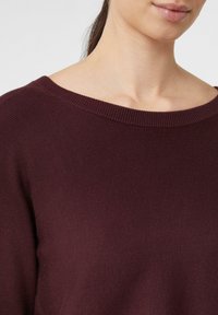Bordeauxfarbener gerippter Pullover mit weitem Ausschnitt, der eine weiche Textur und eine lockere Passform bietet, mit subtilen Nähdetails.