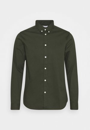 Langarmshirt van donker groene katoenstof. Voorzien van een button-down kraag, knopen aan de voorkant en een recht gesneden zoom. Zachte textuur.