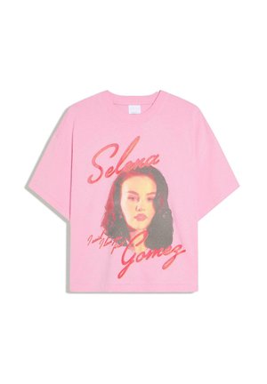 Maglietta rosa con un ritratto in stile vintage di Selena Gomez e il suo nome scritto in grandi lettere corsive sul davanti.