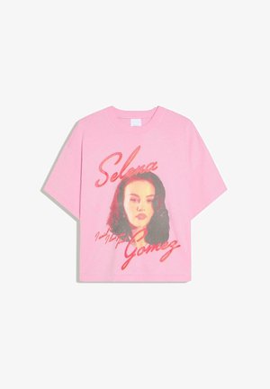 Maglietta rosa con un ritratto in stile vintage di Selena Gomez e il suo nome scritto in grandi lettere corsive sul davanti.
