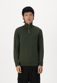 Pull-over en tricot vert avec col montant et demi-zip, doté de manches longues et de poignets et ourlet côtelés. Texture lisse avec des détails minimaux.