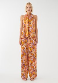 Halsband top en wijde broek set in een bloemige oranje, roze en crème patroon. Gladde stof met een losse pasvorm en minimale hardware.