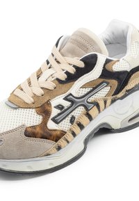 Sneaker featuring a mix of beige, black, and animal-print textures, with mesh panels, suede accents, and black rubber sole.