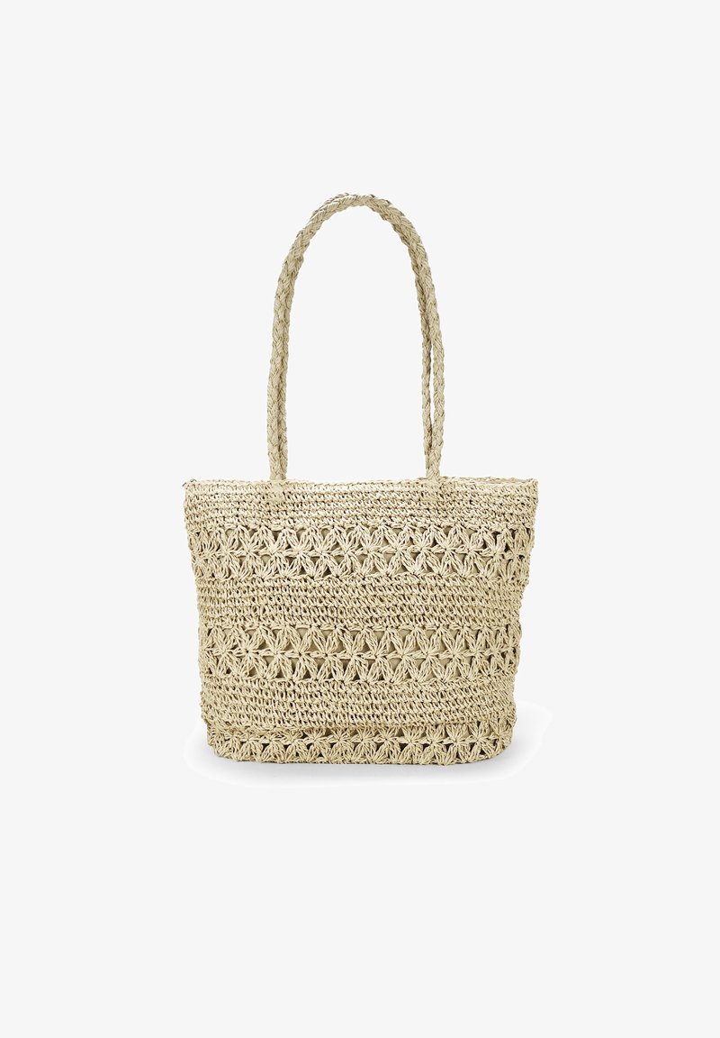 Sac tote beige crocheté avec des motifs floraux et deux bretelles tressées sur fond blanc.