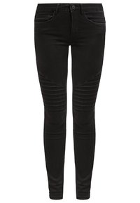 Jean skinny noir avec une texture lisse, des accents côtelés au niveau des genoux et un design traditionnel à cinq poches avec une fermeture à bouton à l'avant.