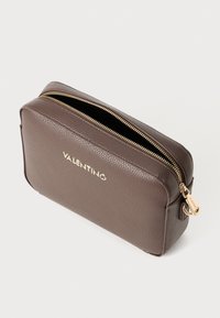 Pochette in pelle marrone con texture, dotata di una cerniera dorata e logo. Forma rettangolare con finitura liscia e accessori metallici.