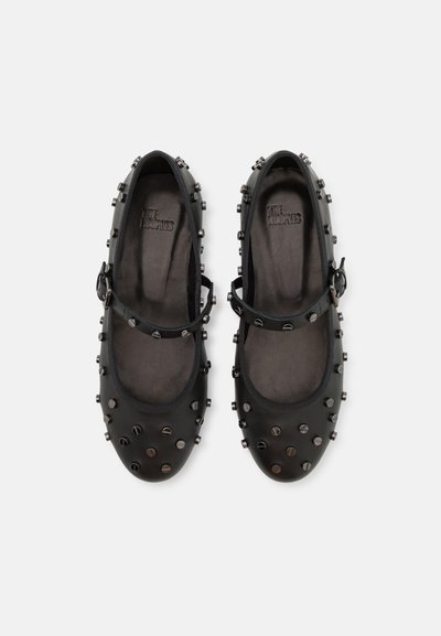Ballerines Mary Jane en cuir noir avec un bout rond, une bride réglable et des clous arrondis sur la surface supérieure. Doublure intérieure lisse.