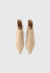 Beige suede ankle boots with a pointed toe and a side zipper detail, featuring a smooth texture and a slim silhouette.