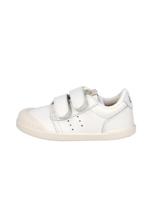 Zapato blanco para niño pequeño con puntera de goma texturizada, dos tiras ajustables de velcro y orificios de ventilación perforados en los lados.