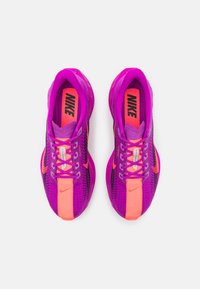 Nike sneakers med en primært lilla overdel og pink detaljer, åndbart mesh-materiale og en struktureret overflade. Bemærkelsesværdigt logo og snørebånd.