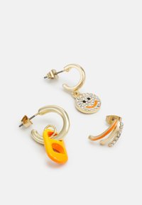 Brincos em tom de ouro com designs circulares e curvados. Um tem um destaque amarelo, e o outro é adornado com cristais transparentes.
