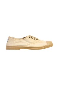 Zapatilla baja de lona beige con puntera de goma, cierre de cordones y suela texturizada, mostrada de perfil sobre fondo blanco.