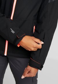 Schwarze Outdoor-Jacke mit orangefarbendem Reißverschluss und Akzenten, verstellbaren Manschetten und einer glatten, leichten Textur. Standardpassform.